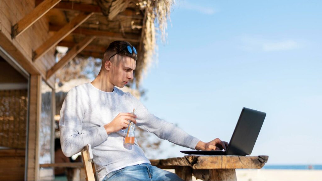 Man working freelance at a beach restaurant