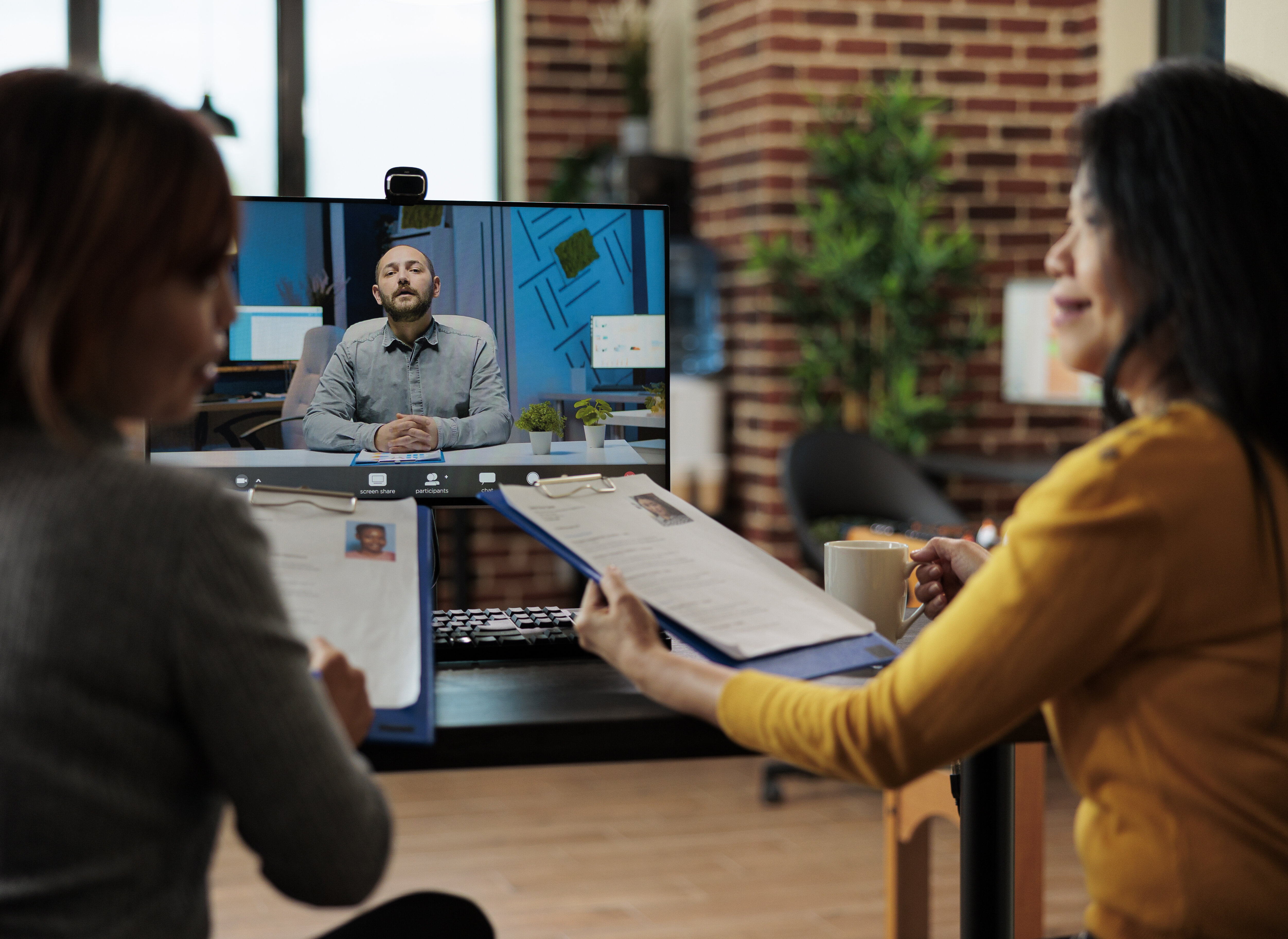 Businesswomen holding clipboard reading recruiter cv discussing company hiring plan during job appointment during online videocall meeting conference in startup office. Teleconference call