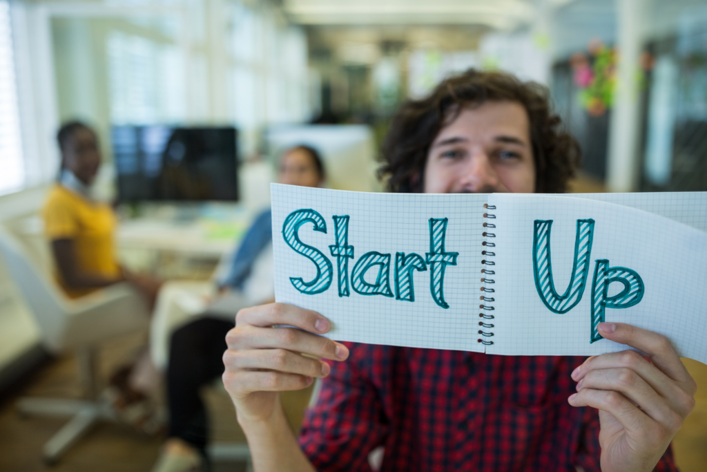 Man holding up a sign that says startup
