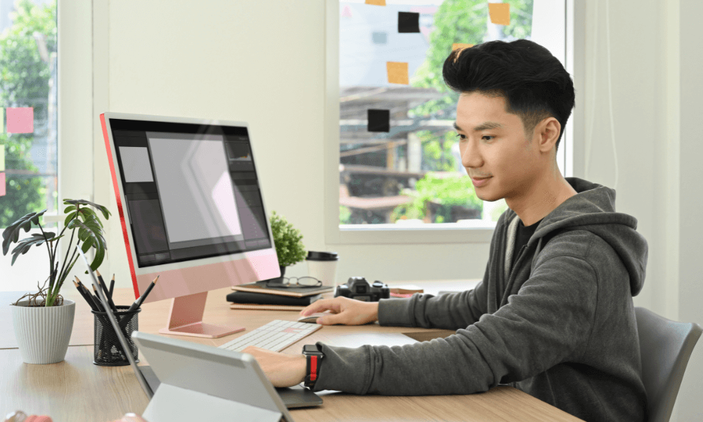 Asian man doing marketing on a laptop and tablet