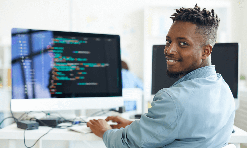 Freelance coder smiling at the camera while developing