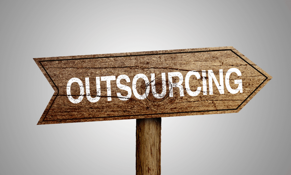 Wooden sign that says outsourcing