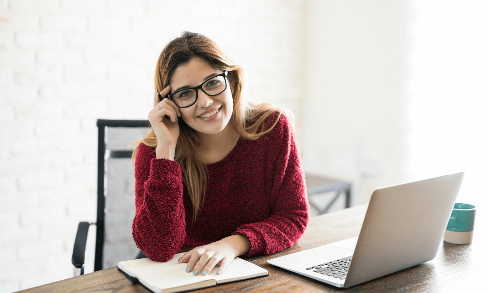 Content marketer with a laptop looking at a camera