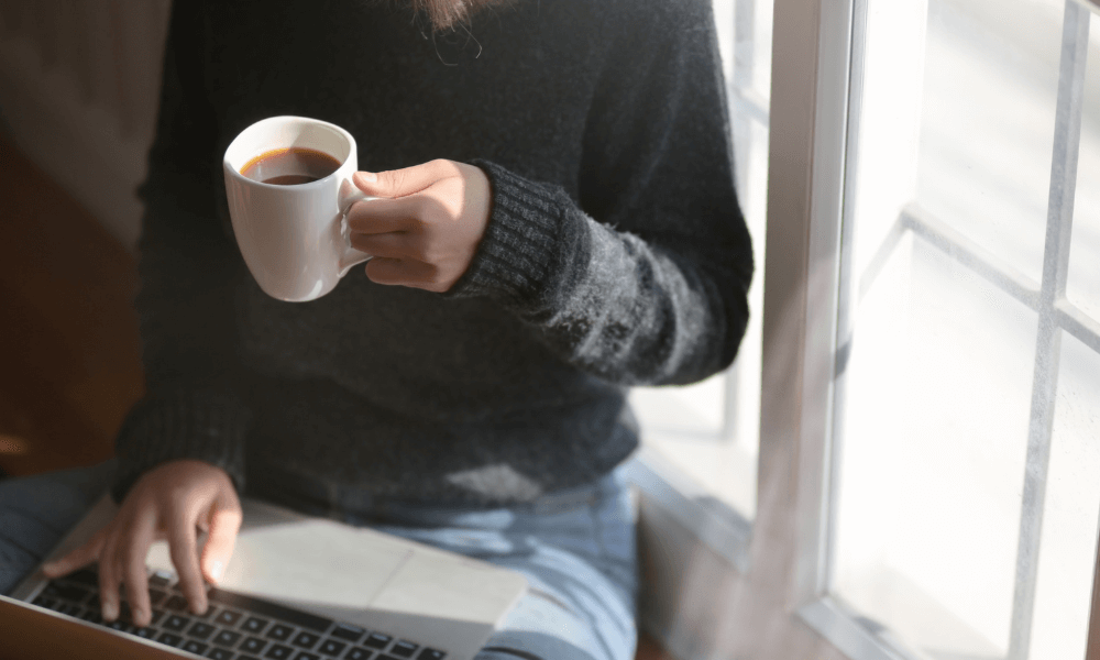 content marketer with a laptop drinking coffee