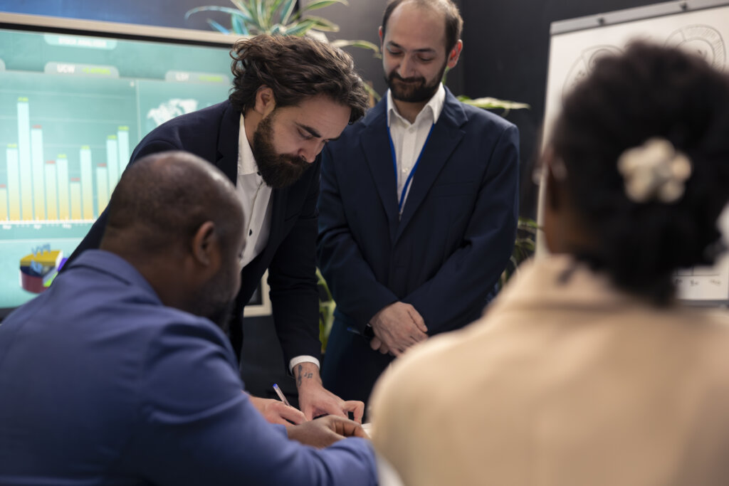 Business partners meeting to share details and exchange impressions about statistics extracted from online research forms. Group collaborating on organizational development plan.