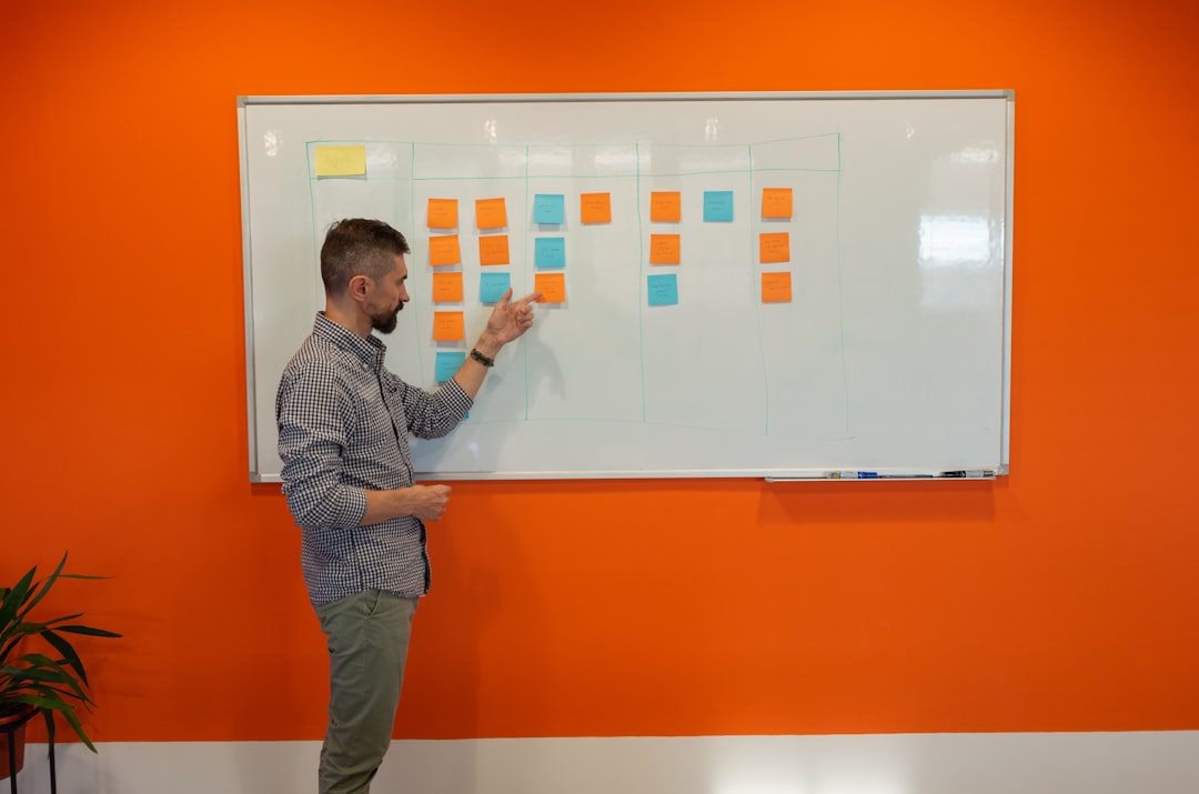 flexible workforce strategy for growing companies - Founder at a whiteboard mapping out team structure with a mix of full-time and contractor roles, sticky notes color-coded by engagement type